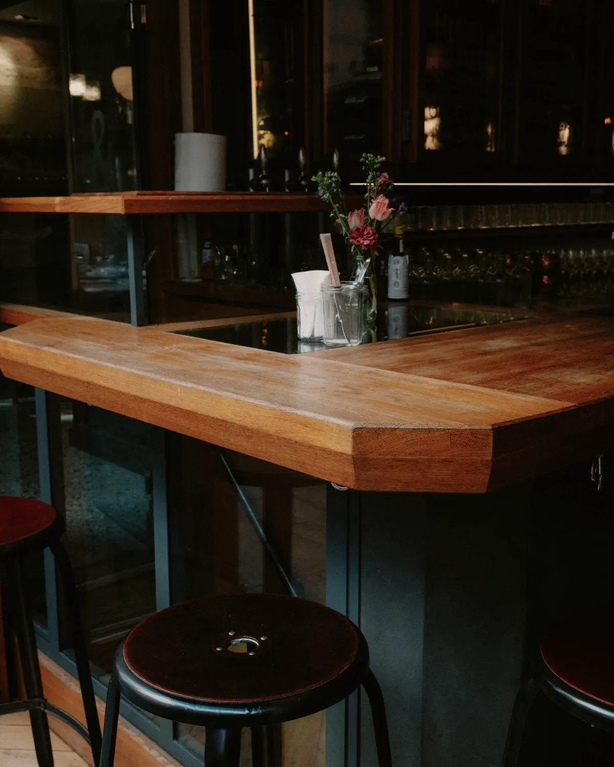 De houten bar met krukken, 's avonds met de lampen aan